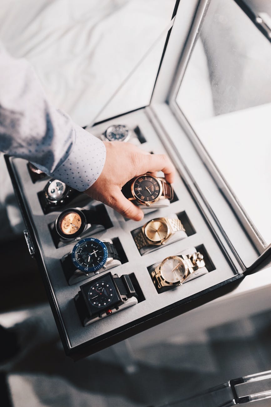person holding round gold colored analog watch with link bracelet How to Protect Your Luxury Assets from Life’s Little Surprises