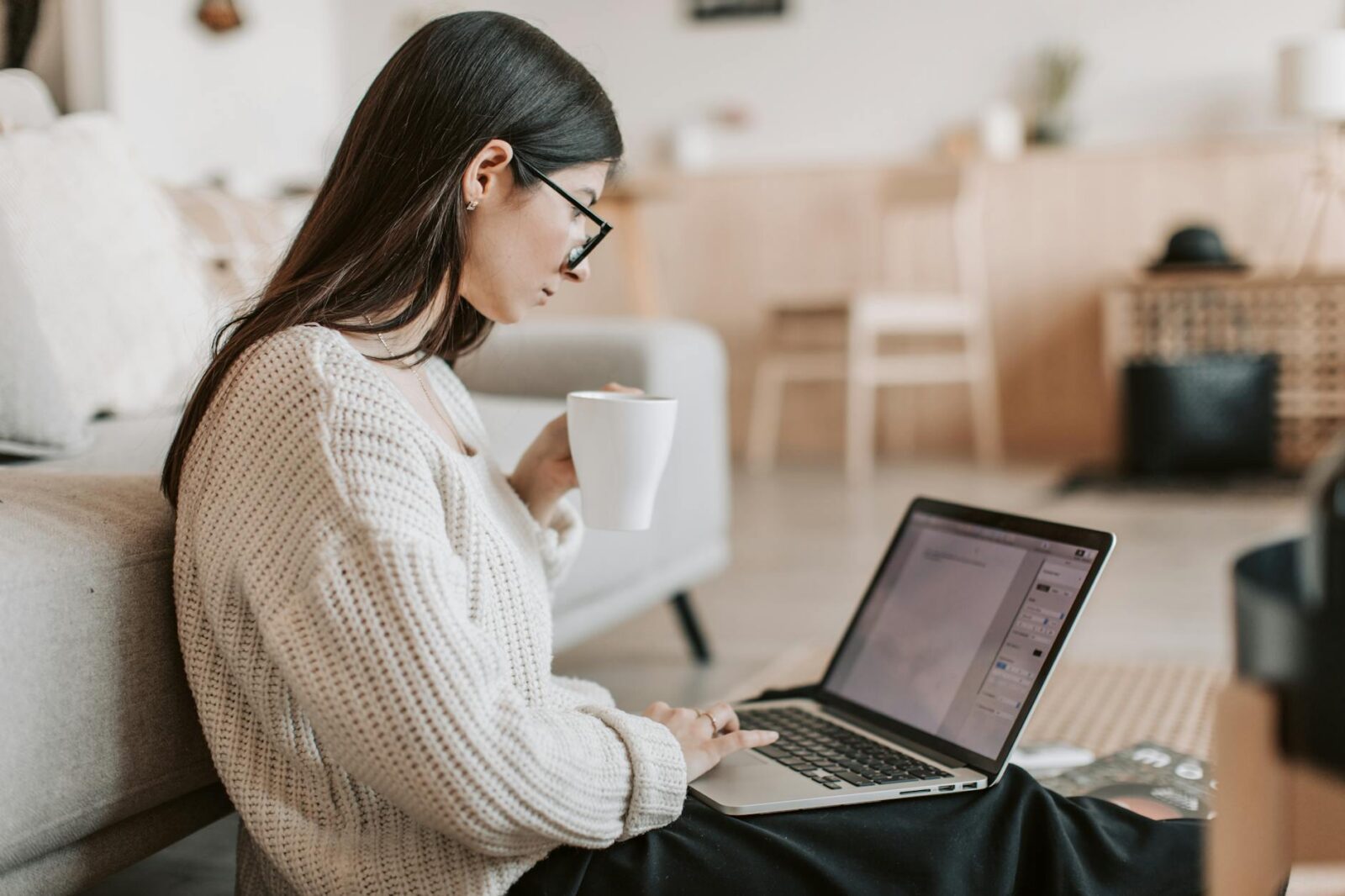 content young businesswoman using laptop while taking tea cup at home 10 Steps to Build a Successful Writing Business