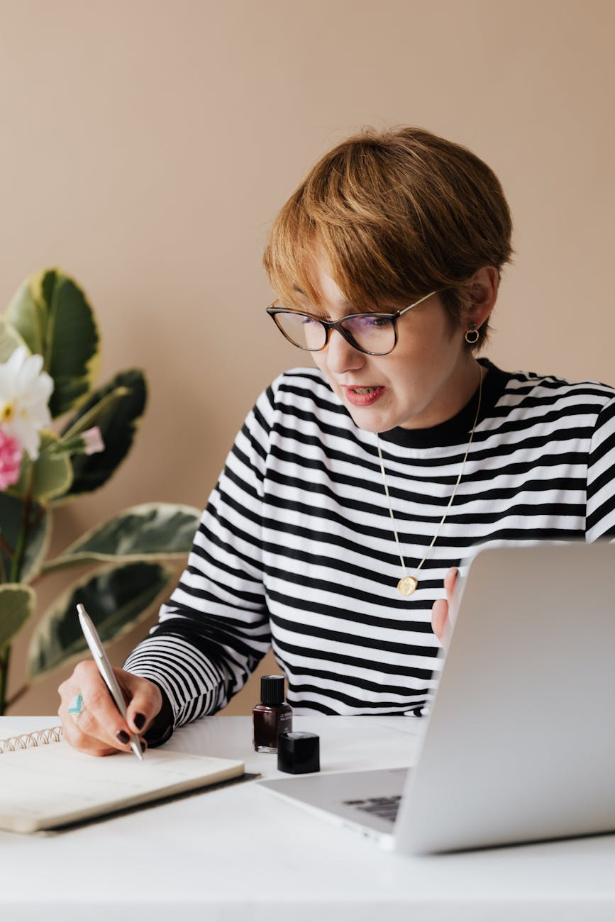 focused woman writing notes in notebook 10 Steps to Build a Successful Writing Business