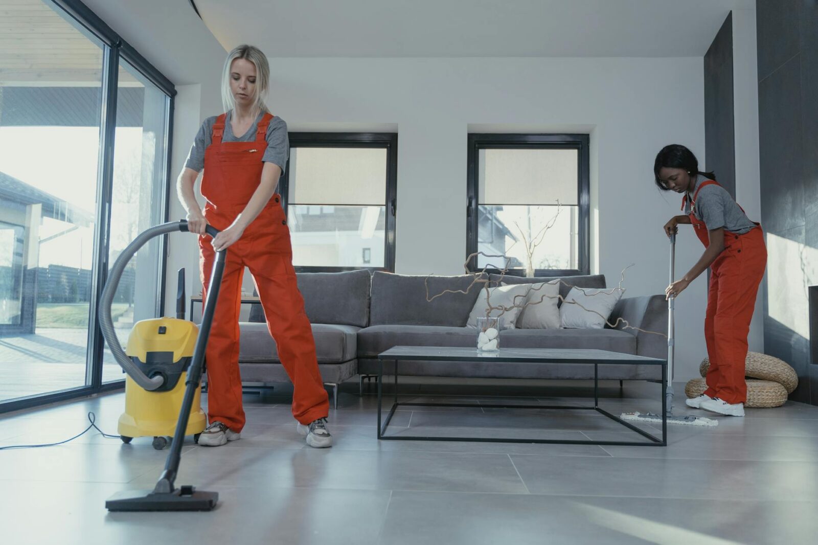 women in orange uniform cleaning the floor 8 Things You’ll Regret Not Doing Before Moving Into Your New Home