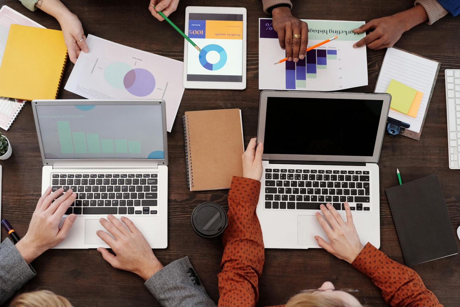 a group of people with graphs and pie charts on table 3 Key Steps to Improve Marketing Efforts for Lasting Growth