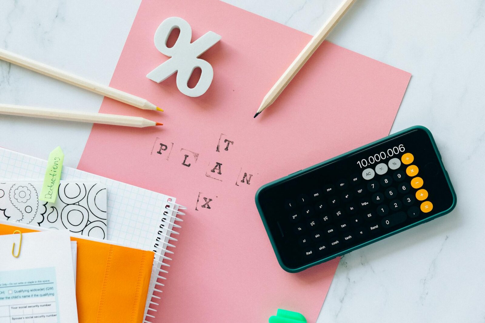 black smartphone on top of pink paper