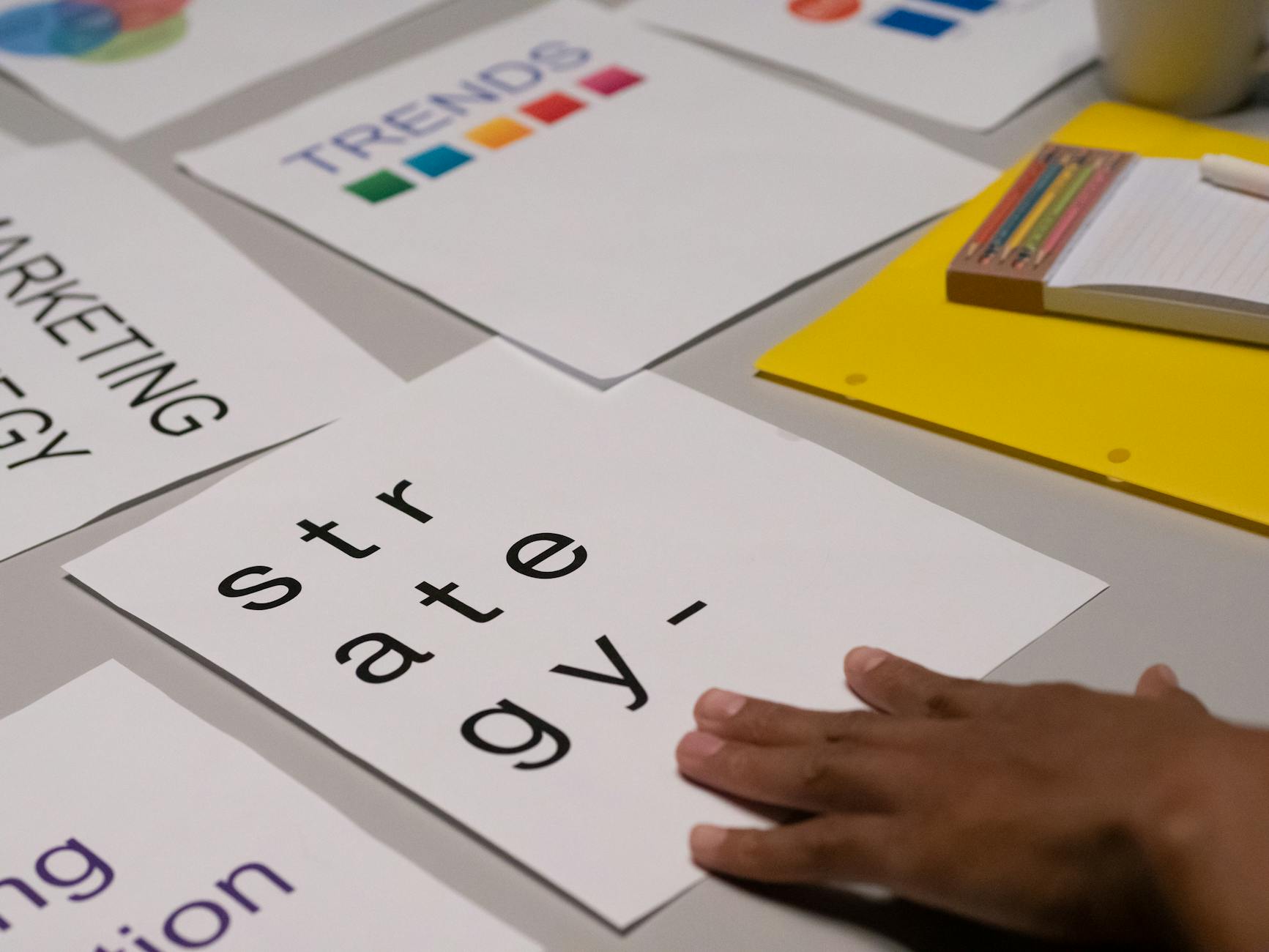 person s hand on white paper 3 Key Steps to Improve Marketing Efforts for Lasting Growth