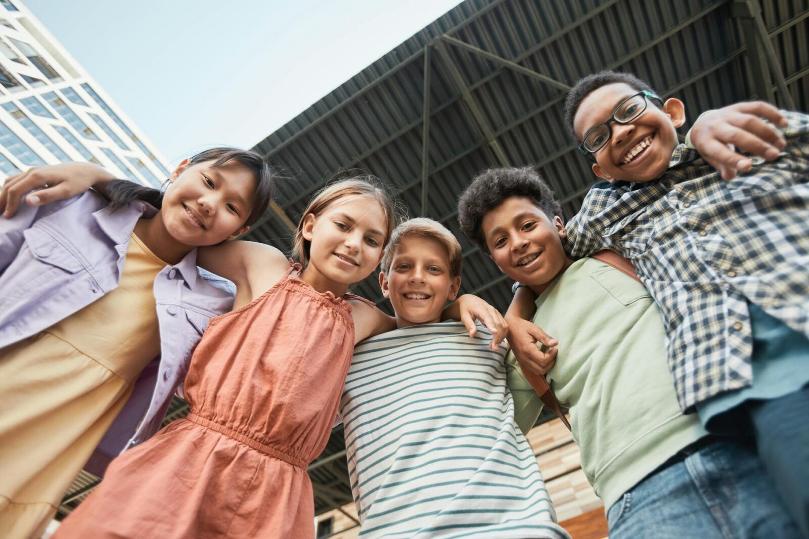 kids arms around each other while smiling at the camera What to Do When Your Child Is Struggling to Make Friends at School