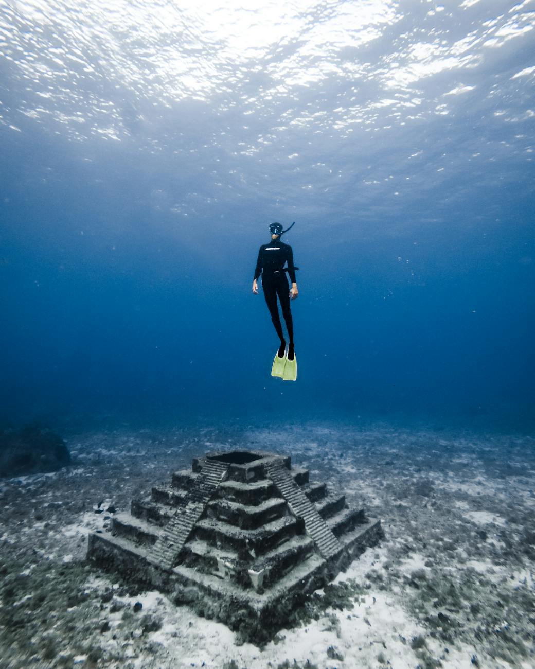 underwater shot of a diver and a built structure 6 Careers That Let You Travel and Work At The Same Time