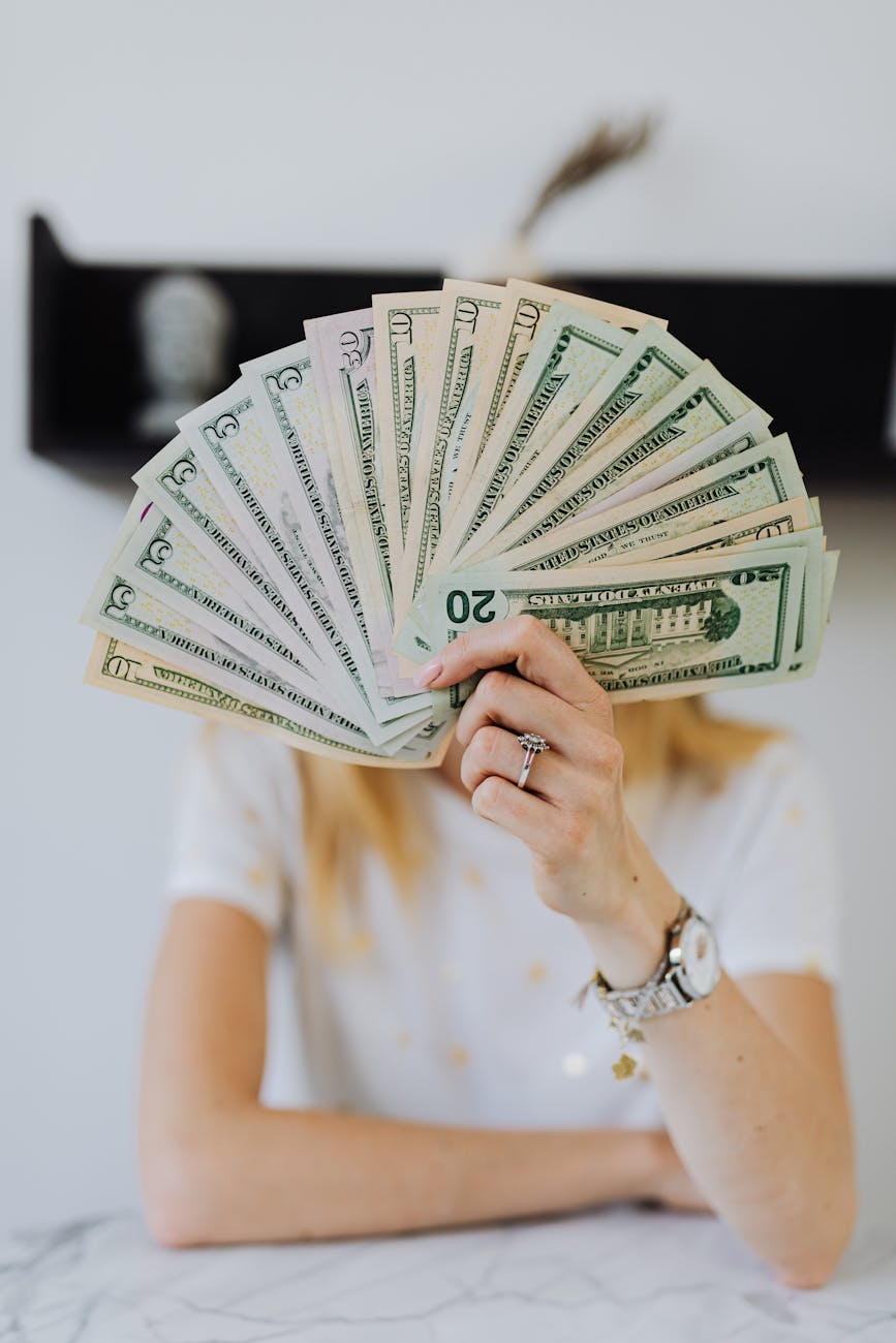 person holding fan of us dollar bills Stop Suffering in Financial Silence: Practical Steps Toward Stability