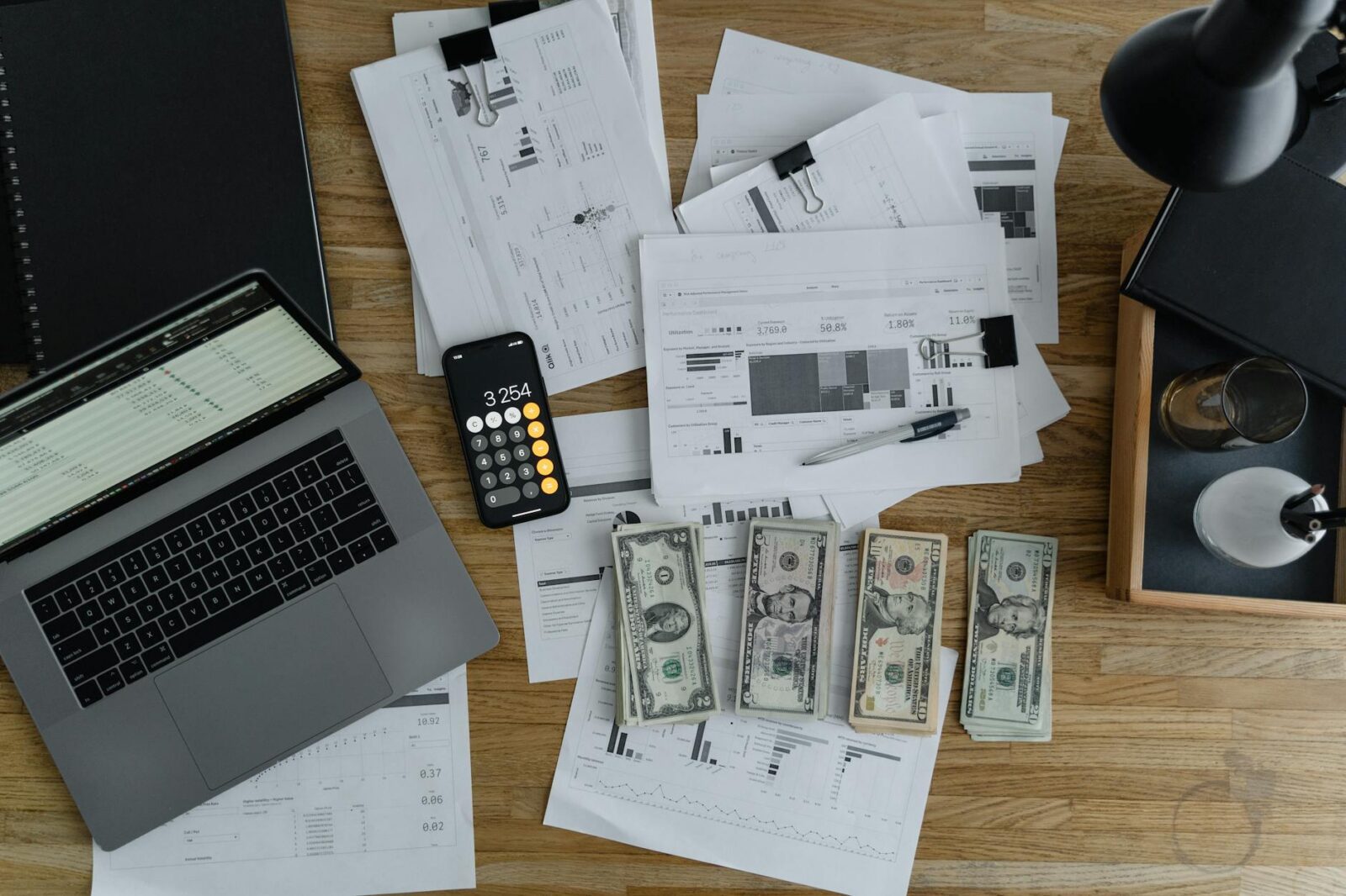 a laptop near the dollars and papers on a wooden table Stop Suffering in Financial Silence: Practical Steps Toward Stability
