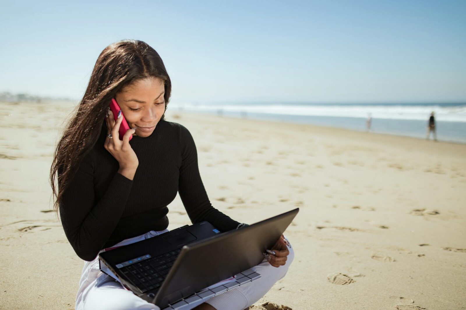 a woman in black long sleeve shirt using laptop computer on beach 6 Careers That Let You Travel and Work At The Same Time