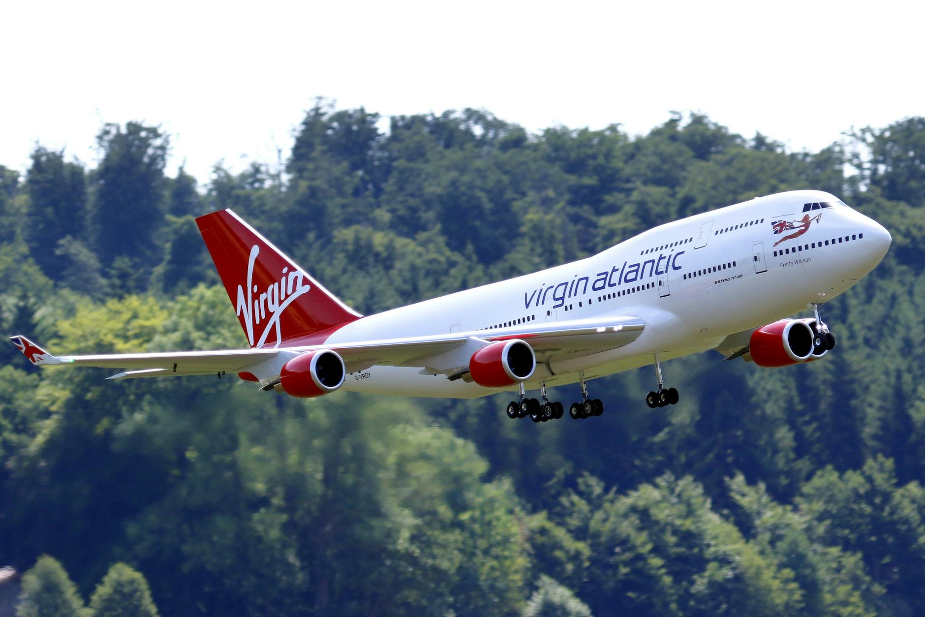 large radio controlled model of a commercial airplane flying against trees Best Airlines to Fly Business Class to the UK from the USA (2026 Guide)