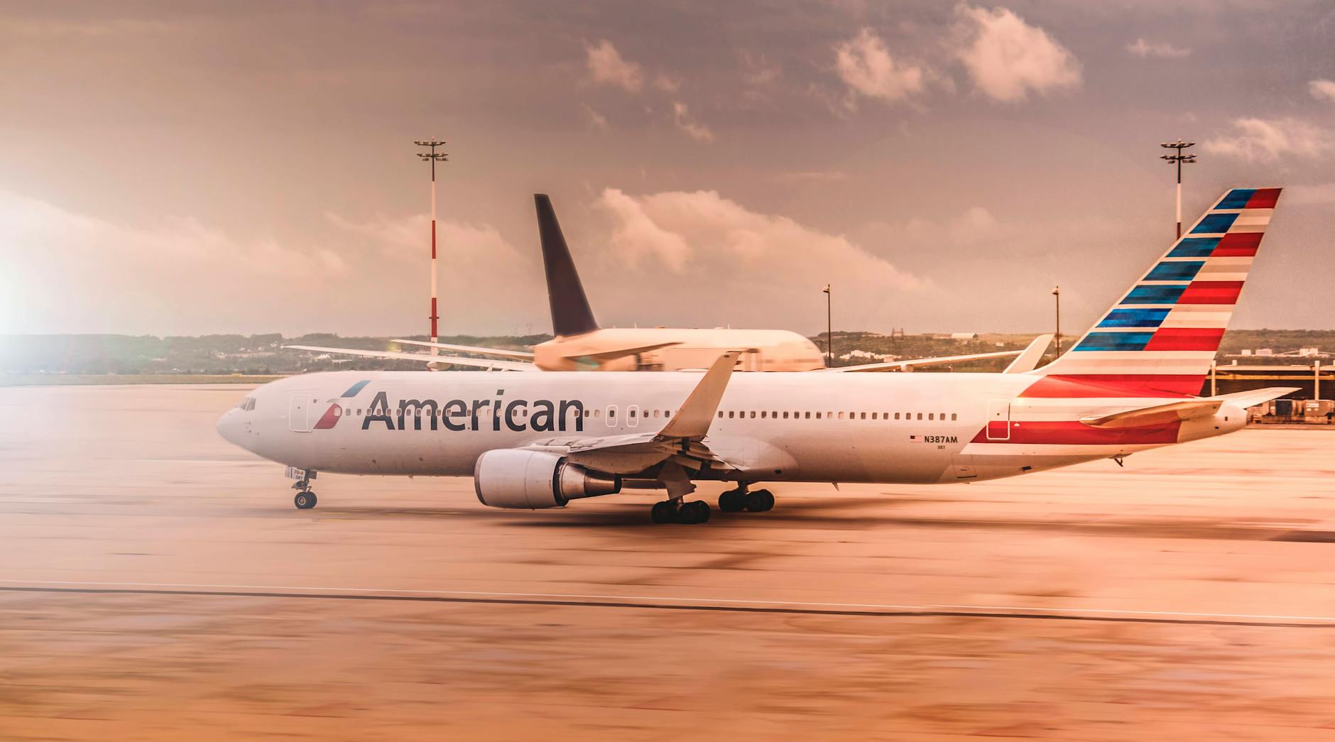 white american airplane parked on airport Best Airlines to Fly Business Class to the UK from the USA (2026 Guide)