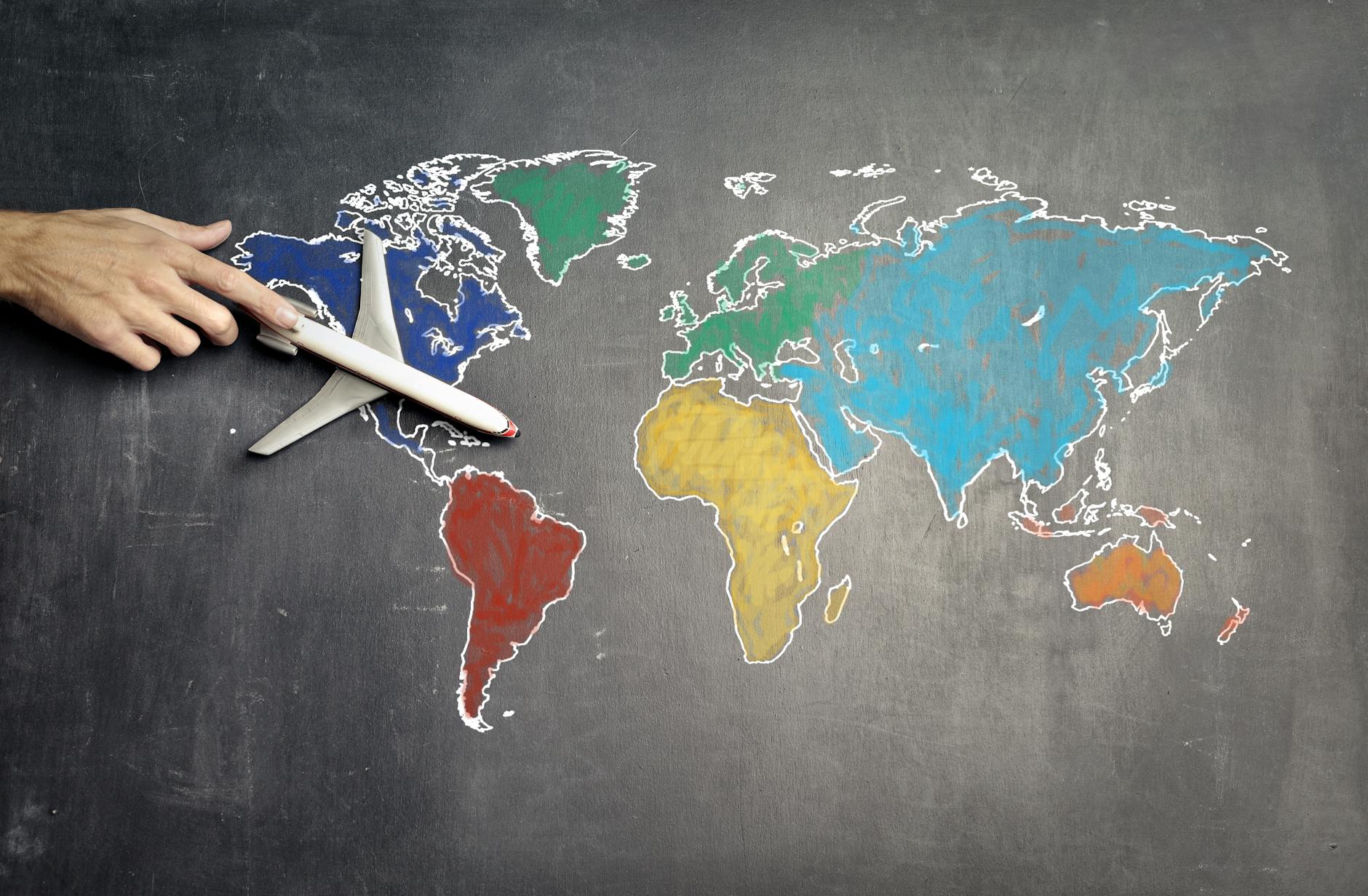 person with toy airplane on world map Best Airlines to Fly Business Class to the UK from the USA (2026 Guide)