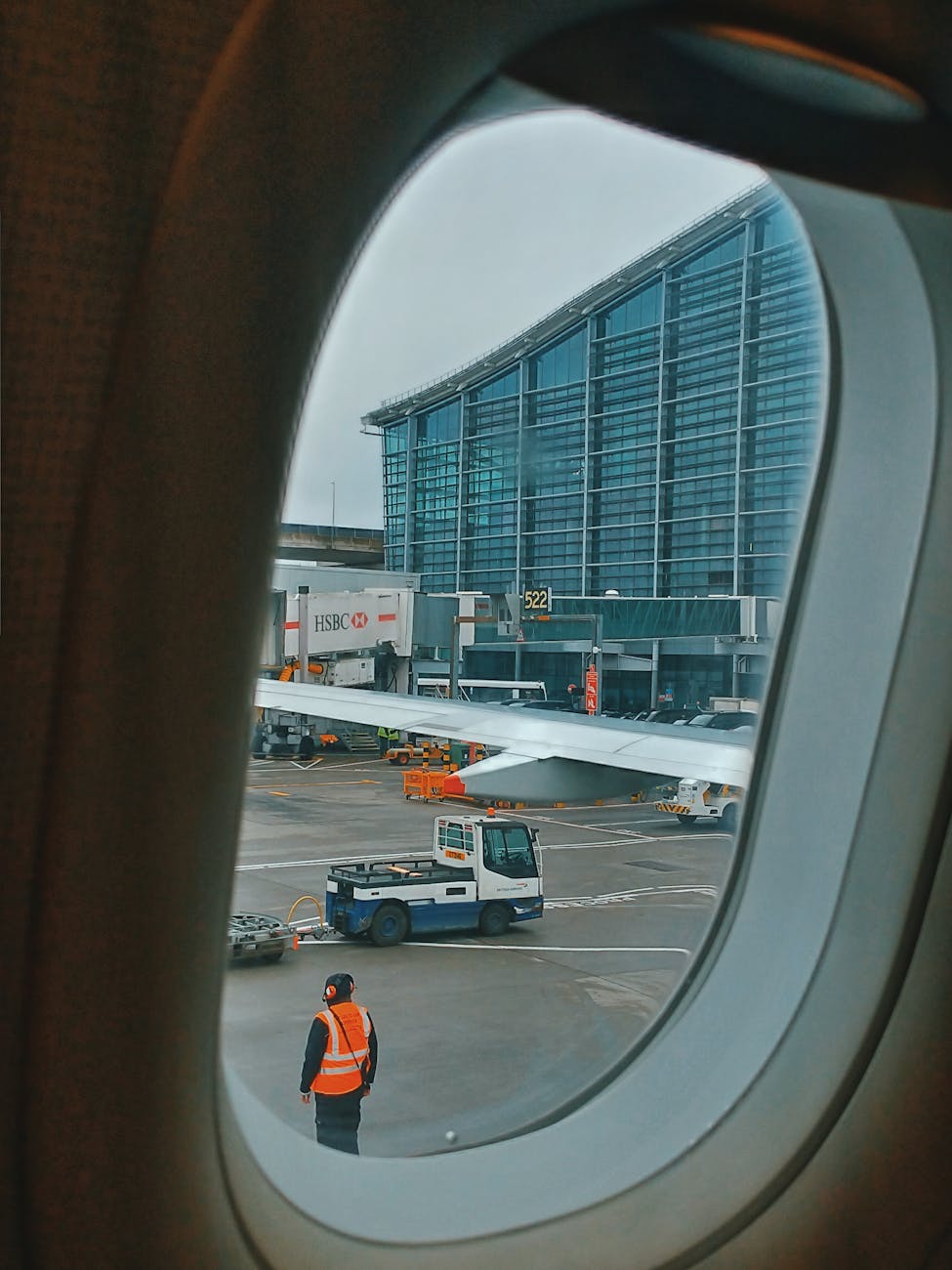 airport through window of plane Best Airlines to Fly Business Class to the UK from the USA (2026 Guide)