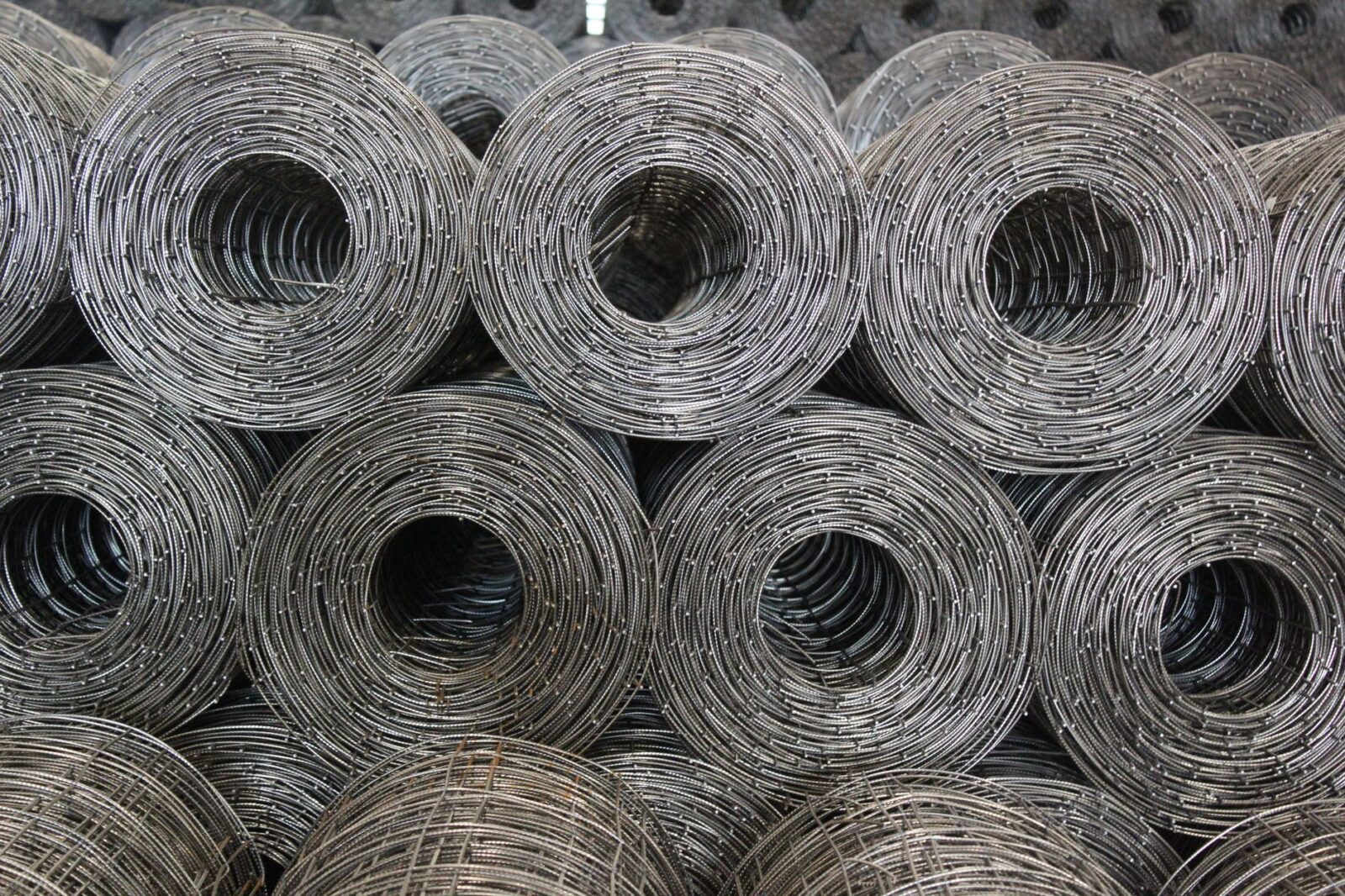 Cattle Fence Design: Planning Corrals, Gates, and Working Pens 9 coiled steel wire mesh rolls in warehouse Cattle Fence Design: Planning Corrals, Gates, and Working Pens